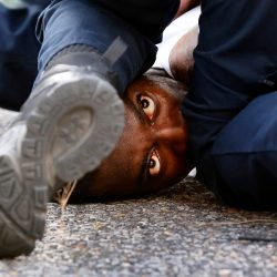 A man is detained by law enforcement while protesting the shooting death of Alton Sterling outside the headquarters of the police department in Baton Rouge, Louisiana