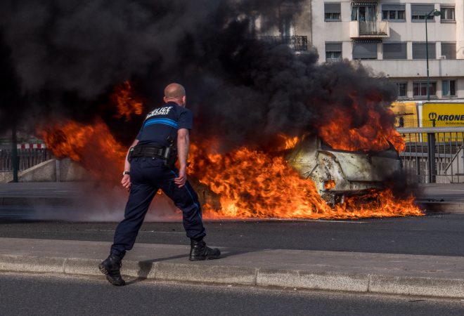 Fired up policeman trying to blow out a fire