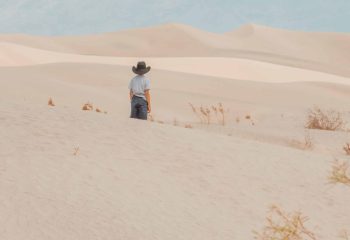Little boy staring at sand dunes.