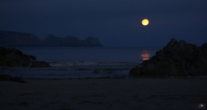 Lune orange sur l'océan à l'aube